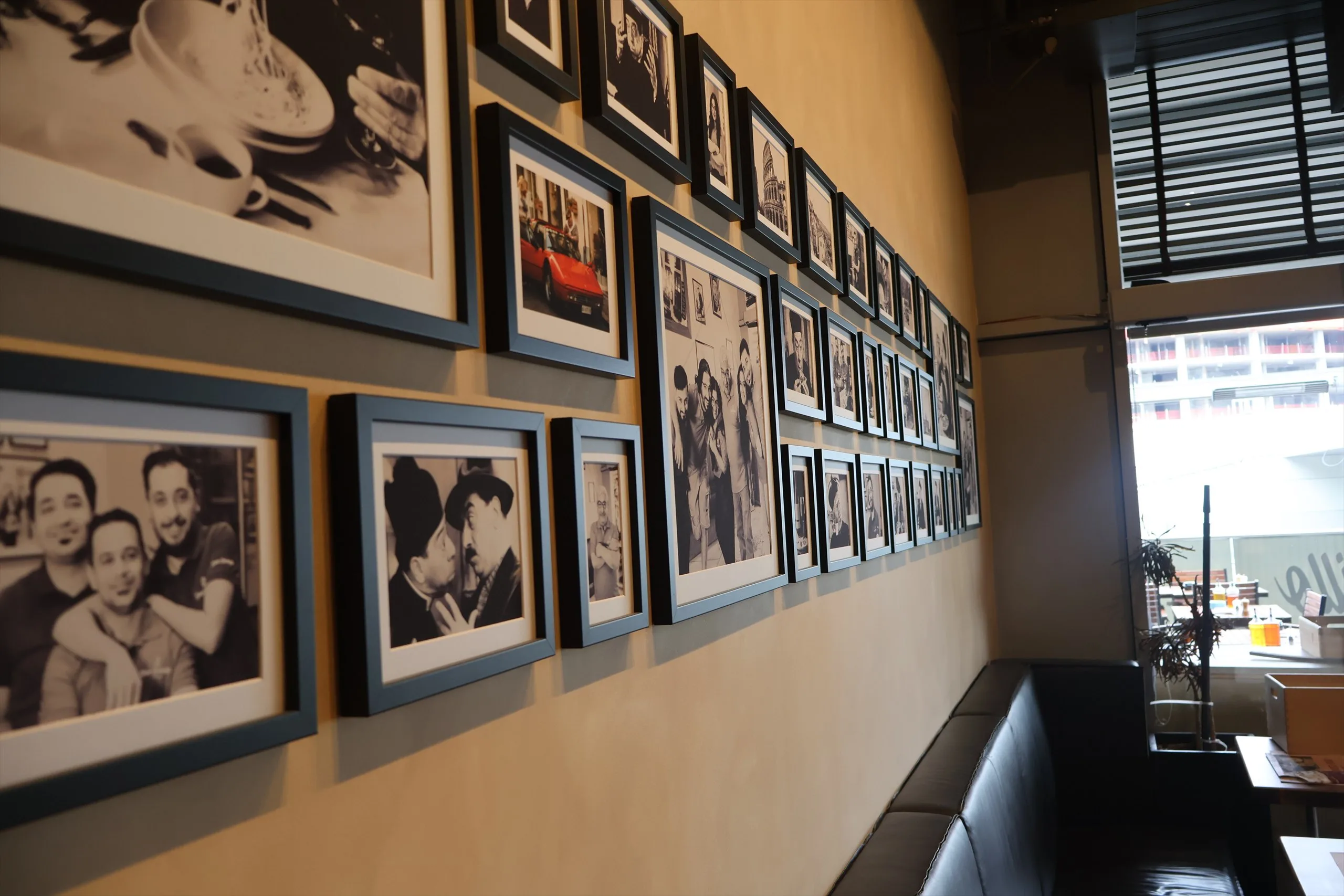 Wand mit gerahmten Schwarzweißfotos im Lokal am Olympiaplatz